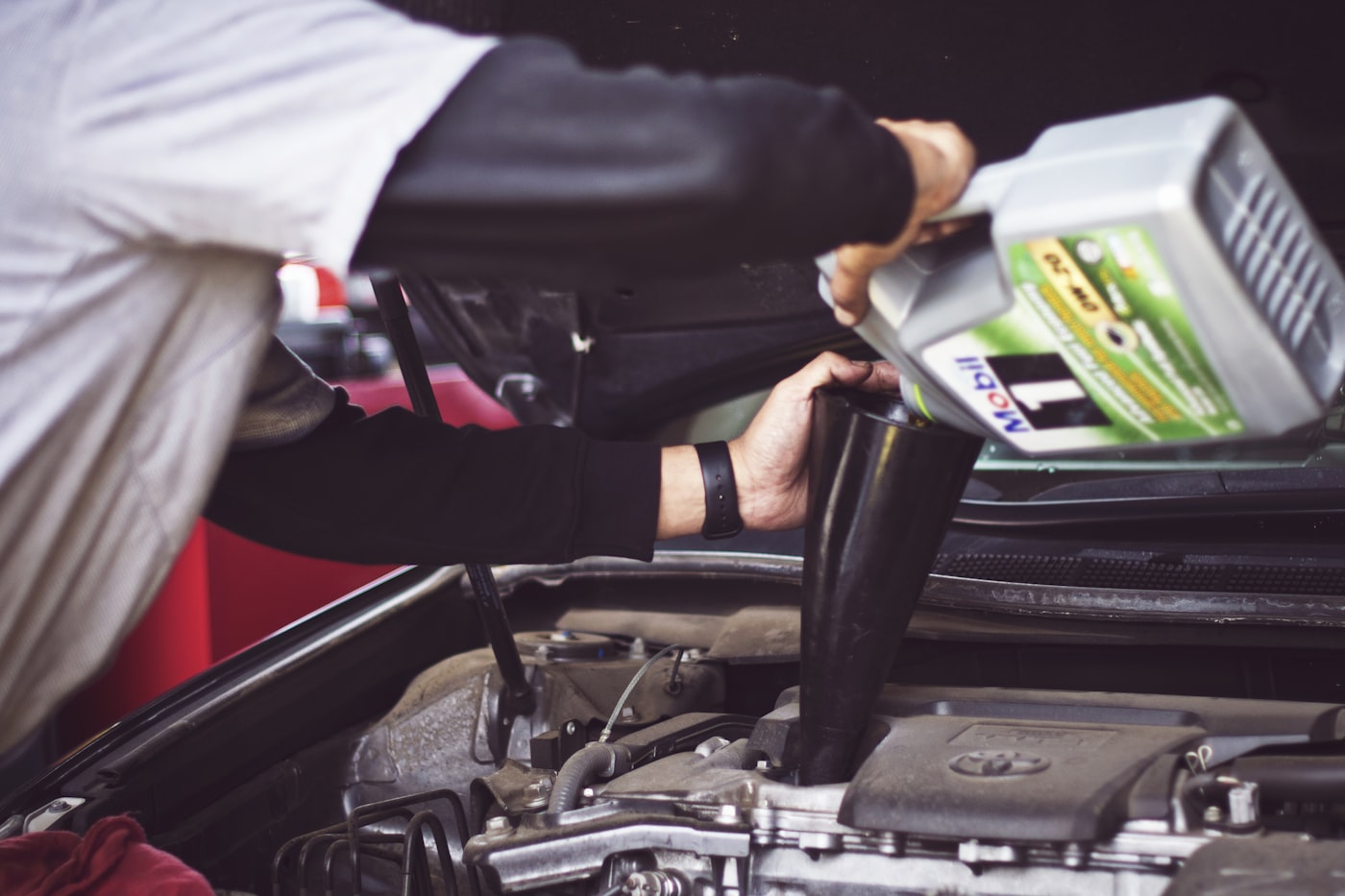 Mechanic servicing a vehicle engine — predictive maintenance and total cost of ownership in fleet management software
